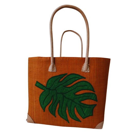 Orange woven basket with monstera embroidery. handmade in Madagascar. 