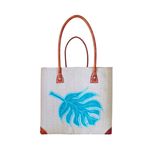 NatsNco handmade raffia, women,beige basket with turquoise leaf embroidery and leather handle & drawstring closure. Made in Madagascar